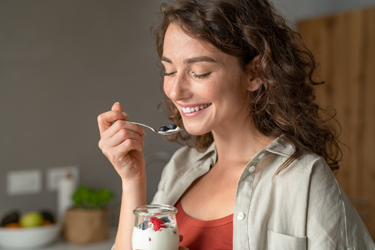 Lady eating yogurt.